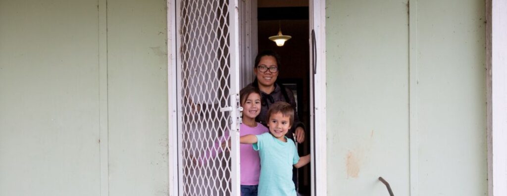 family in the doorway of their social house